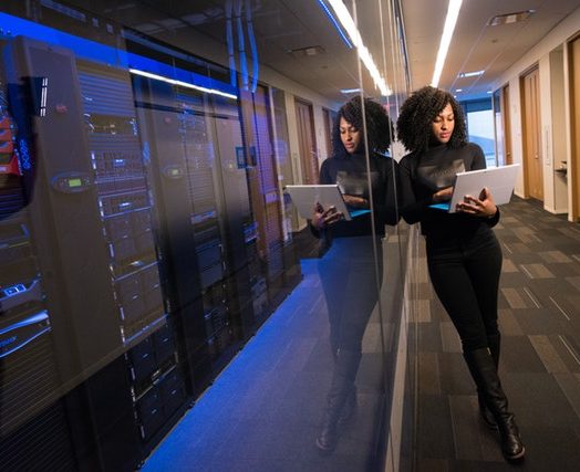 woman holding laptop beside glass wall 1181316