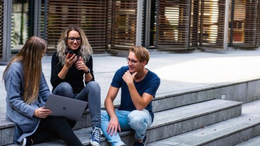 Three Persons Sitting On The Stairs Talking With Each Other 1438072