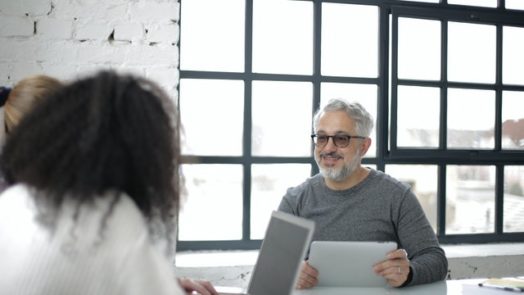 positive adult man with tablet working with colleagues in 3932236