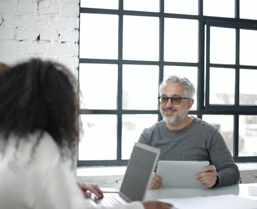 positive adult man with tablet working with colleagues in 3932236